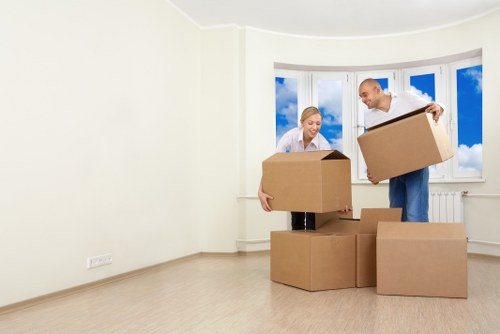 Professional movers navigating stairs in a Holland Park property